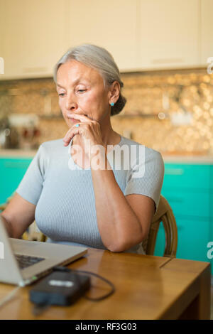 Portrait of senior woman using laptop Stock Photo