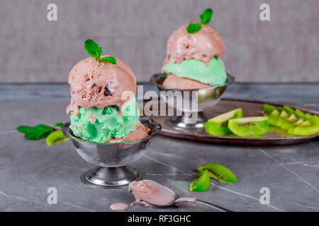 Pistachio and chocolate ice cream in a clay bowl on stone background. Stock Photo