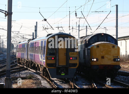 Class 158 dmu in Northern livery joining West Coast Main Line and passing class 37 diesel-electric locomotive arriving at Carnforth from the WCML. Stock Photo