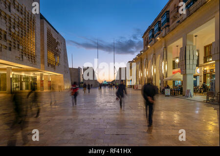 Valletta at night. View along Republic Street towards the city gates and Triton Fountain at dusk. Stock Photo