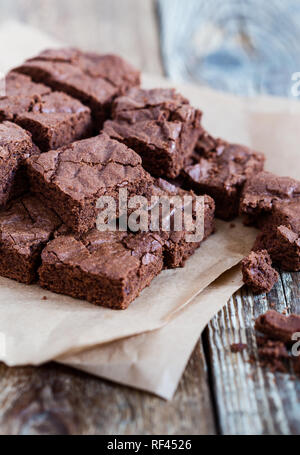 Pieces of freshly baked chocolate brownie on rustic wooden board, close-up, selective focus Stock Photo