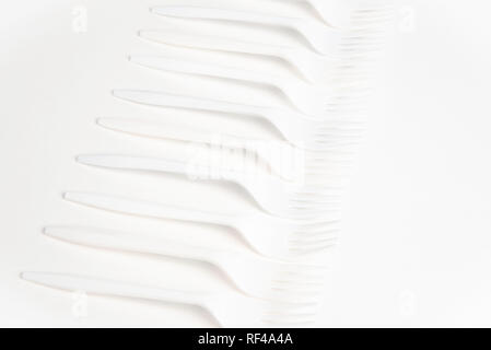 A bunch of white disposable single-use plastic forks commonly available all over the world. Stock Photo
