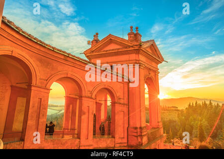 Side view of Sanctuary of Blessed Virgin of San Luca and Colle della Guardia above city of Bologna. Scenic sunset light. Famous landmark cityscape in Emilia-Romagna, Italy. Stock Photo
