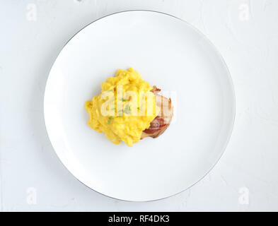 Scrambled eggs on plate over white stone background. Top view, flat lay Stock Photo