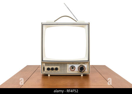 Grungy vintage portable television with cut out screen and old wood table isolated on white. Stock Photo