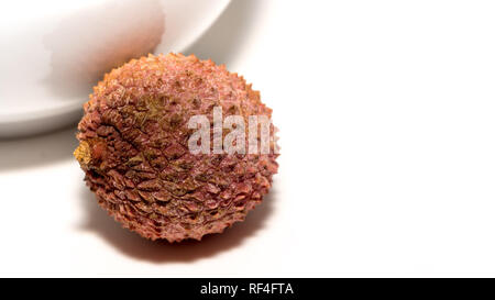 Single lychee fruit, against a white background, detail-taking Stock Photo