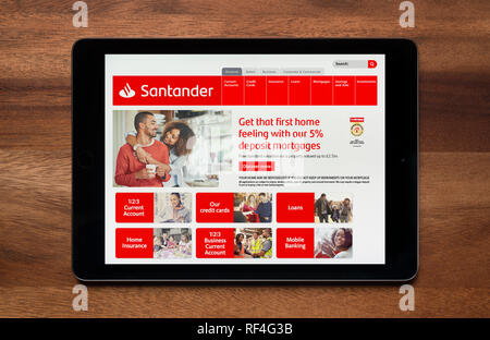 The website of Santander Bank is seen on an iPad tablet, which is resting on a wooden table (Editorial use only). Stock Photo