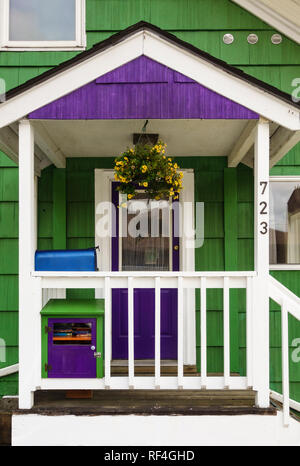 Front porch and door of a typical old historic wood frame house in Juneau, Alaska with brightly painted shingles siding Stock Photo