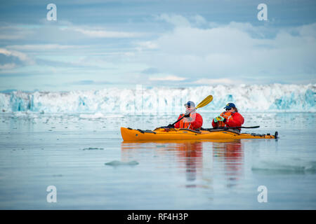 SVALBARD, Norway — Kayaking tourists explore the icy waters and pristine landscapes of the Arctic region surrounding Svalbard. This unique and adventurous form of tourism offers an up-close experience with the Arctic environment, showcasing the region's breathtaking beauty and fragile ecosystems. Stock Photo