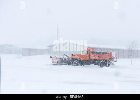 A snow plow removing snow on a street during a blizzard. Stock Photo