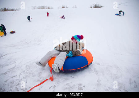 Sledding.Happy child on vacation. Winter fun and games.Little boy enjoying a sleigh ride.Children play outdoors in snow. Kids sled in the Alps mountai Stock Photo