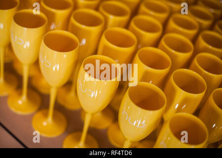 Many yellow plastic wine glasses on a table. Stock Photo