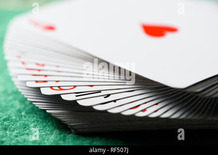 selective focus of unfolded playing cards on green table Stock Photo