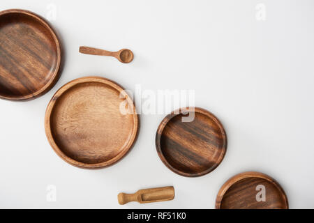 top view of wooden bowls, spoon and spatula on white background Stock Photo