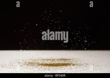 selective focus of white table with bright sparkles isolated on black Stock Photo