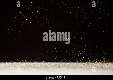 white table with bright shiny sparkles isolated on black Stock Photo