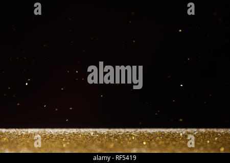 table with bright golden sparkles isolated on black Stock Photo