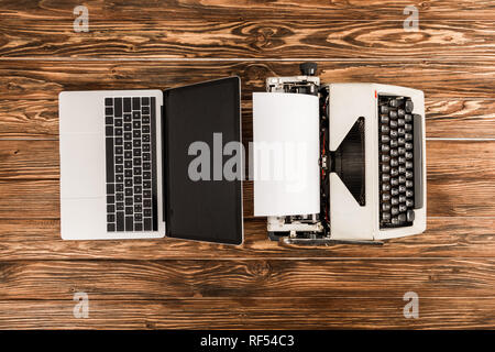 top view of typewriter and laptop on wooden table Stock Photo