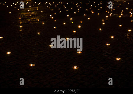 A lot of lit outdoor candles(also known as pitch torch or a garden candle), a lot of out of focus candles burning on the background at night. Stock Photo