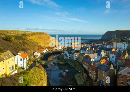 View looking seawards over the harbour of the North Yorkshire Village of Staithes with Cowbar on the North side of Roxby Beck Stock Photo