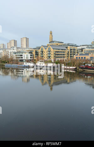 Houseboats on the River Thames with the new Kew Bridge Road housing development in the foreground and Brentford Towers housing estate in the background Stock Photo
