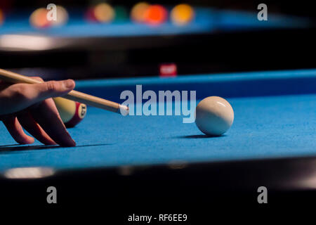 Playing billiard. Billiards balls and cue on blue billiards table Stock Photo