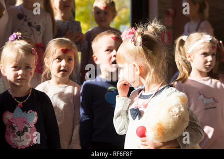 . Holiday in the city. Children's Pavilion.Little girl looks at other children. Stock Photo