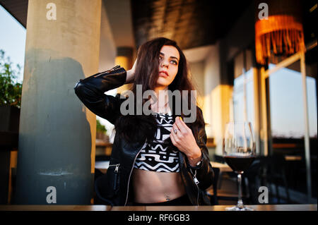 Young curly woman enjoying  her wine in a bar. Stock Photo