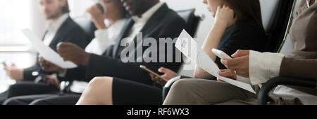 Side horizontal photo multiracial people sitting in queue waiting interview Stock Photo