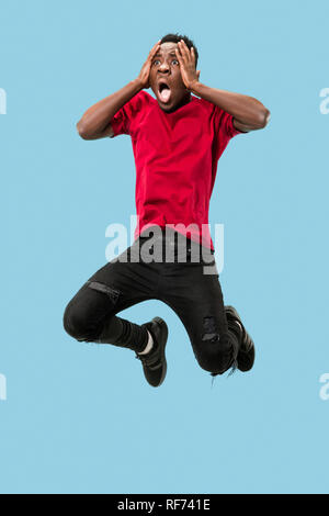 Wow. Attractive male portrait on blue studio backgroud. Young emotional surprised afro man jumping with open mouth. Human emotions, facial expression concept. Trendy colors Stock Photo