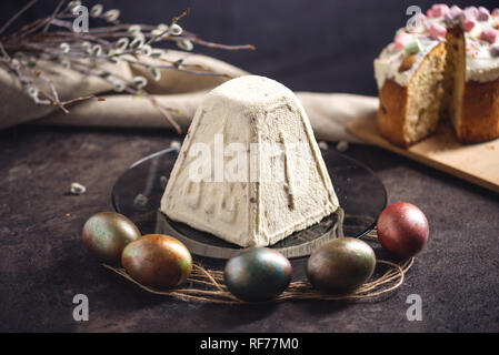 Card with traditional desserts and colorful eggs in rustic style on a dark background. Concept happy Easter Stock Photo