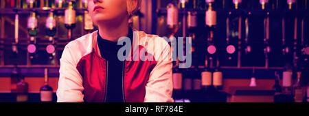 Female bartender standing at bar counter Stock Photo