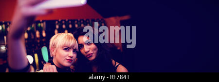 Friends posing while taking selfie in bar Stock Photo
