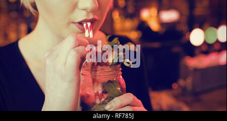 Beautiful woman having cocktail in bar Stock Photo