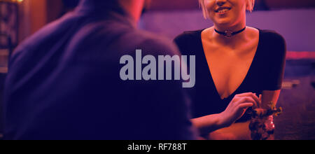 Couple talking while enjoying the drinks at counter Stock Photo