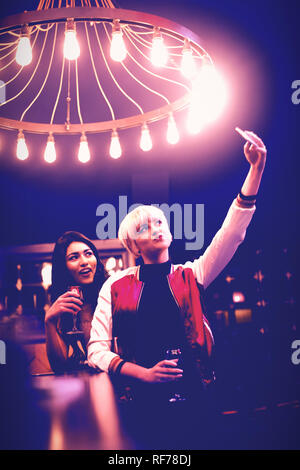 Smiling friends taking a selfie while having wine Stock Photo