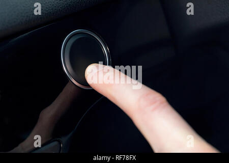 Finger pressing a button in a car Stock Photo