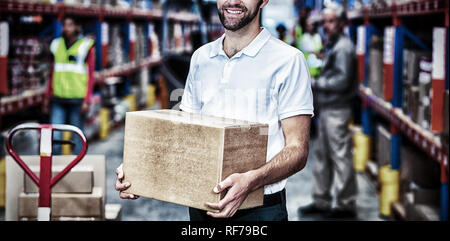 Portrait of worker is holding cardboard boxes and smiling to the camera Stock Photo