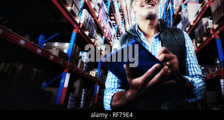 Worker is smiling and holding a clipboard in a warehouse