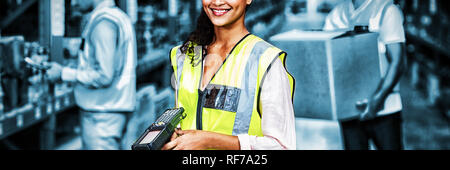 Portrait of female warehouse worker standing with barcode scanner Stock Photo