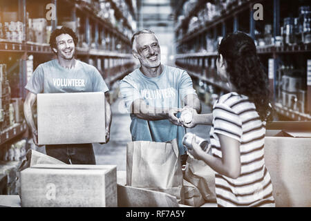 Woman gives some goods to volunteer Stock Photo