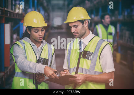 Workers looking at clipboard Stock Photo