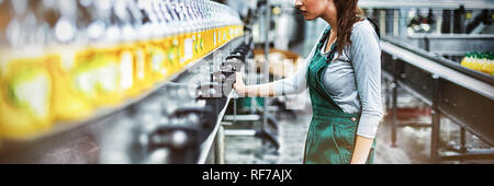 Female factory worker standing near production line Stock Photo