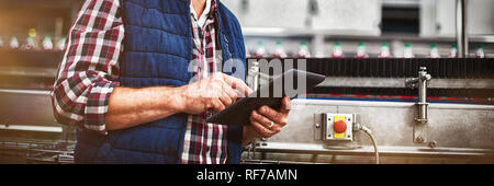 Smiling factory worker using digital tablet in the factory Stock Photo
