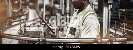 Factory worker using a digital tablet near the production line Stock Photo