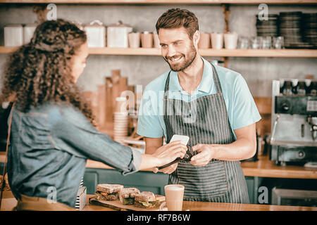 Woman paying bill through smartphone using NFC technology Stock Photo