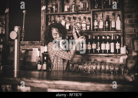 Female bartender mixing a cocktail drink in cocktail shaker Stock Photo
