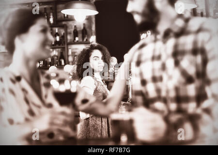 Jealous woman looking at couple flirting with each other Stock Photo