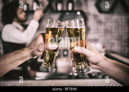 Cropped image of men toasting beer glass Stock Photo