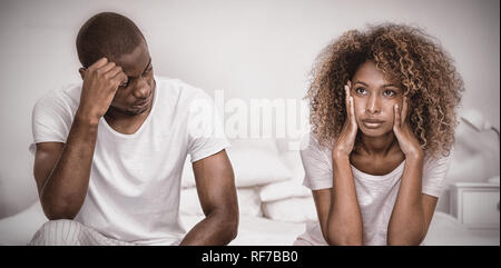 Upset couple ignoring each other after fight on bed Stock Photo